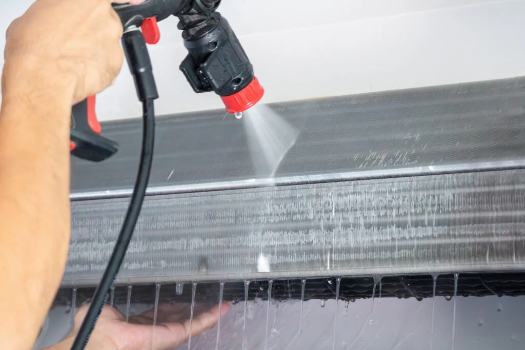 AC cleaning service technician using water spray in Hyderabad